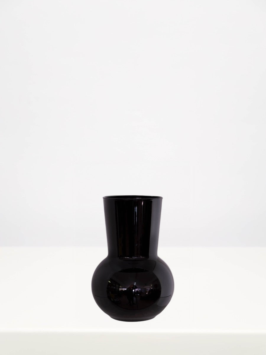 Black Adele Mini Vase - 17cm on a white table against a soft grey wall