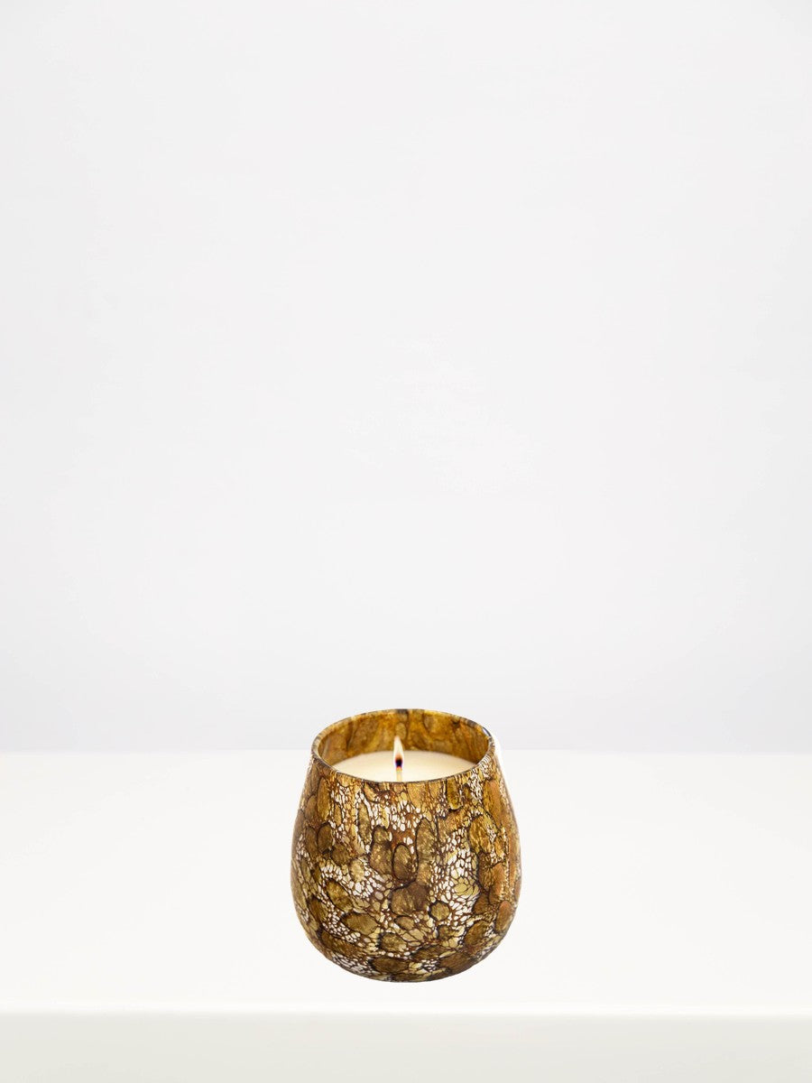 Fidrio - Gold Midnight Velvet Candle - Medium on a white table against a soft grey wall