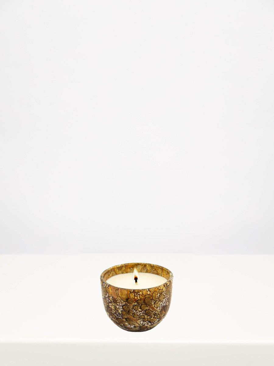 Fidrio - Gold Midnight Velvet Candle - Small on a white table against a soft grey wall