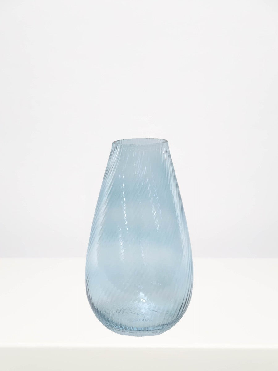 Soft Blue Ribbed Vase - 25.5cm on a white table against a soft grey wall