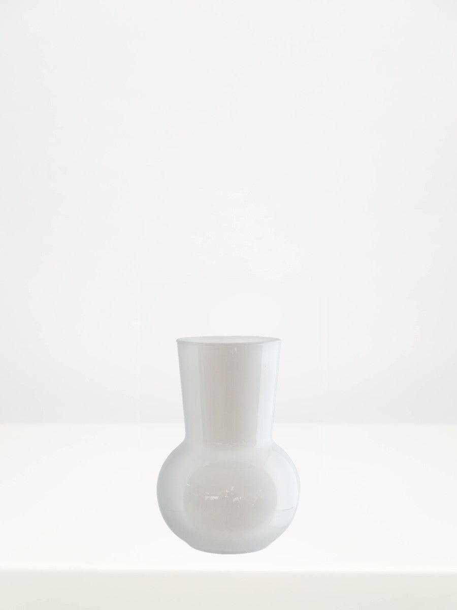 White Adele Mini Vase - 17cm on a white table against a soft grey wall